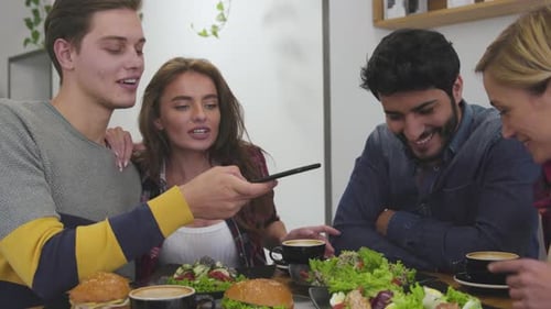 People taking food photos on mobile phone at restaurant.