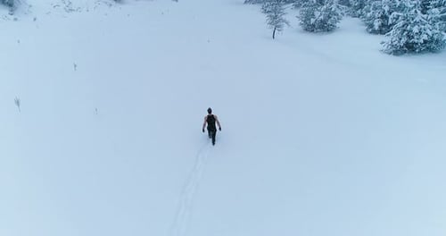 Athletic man walking on snow.