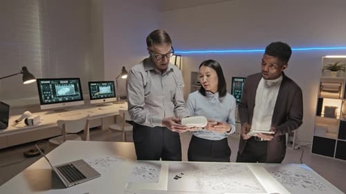 Engineers Collaborating on Headset Design in Modern Office