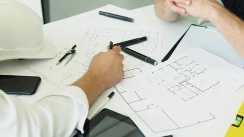 Ingenieurteam diskutiert auf dem Zeichentisch zur Planung der Arbeit im Projekt und bei Immobilien