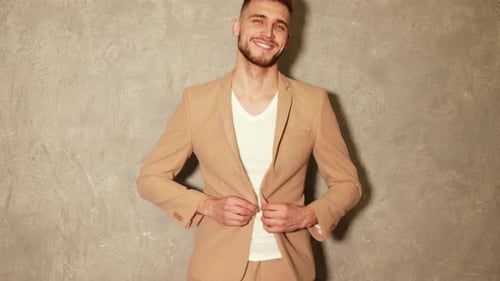 Portrait of attractive bearded stylish young man looking into the camera and smiling