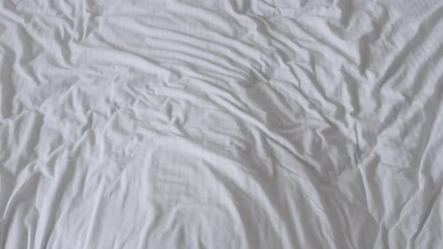 Happy Man and Woman Falling on the Bed and Looking at Each Other with Love. Young Couple Lying in