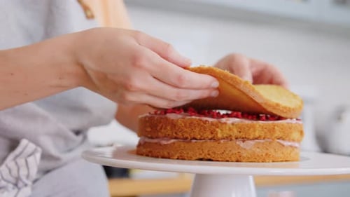 Woman Prepares Three-Layer Cake in Kitchen