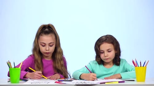 Children Sisters, Decorate the Picture with Pencils. White Background. Slow Motion