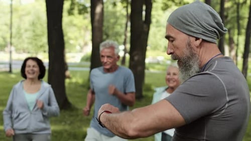 Active Senior Group Exercising Outdoors with Trainer