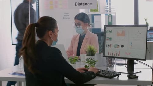 Office Workers Using Computers and Wearing Masks