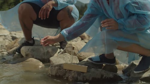 Closeup of Environmentalist Hand in Process of Taking Sample of Water From Polluted River