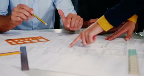 Architects Reviewing Blueprints in Modern Office