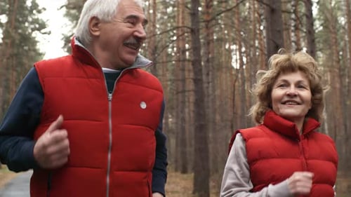 Couple of Seniors Jogging in Woods