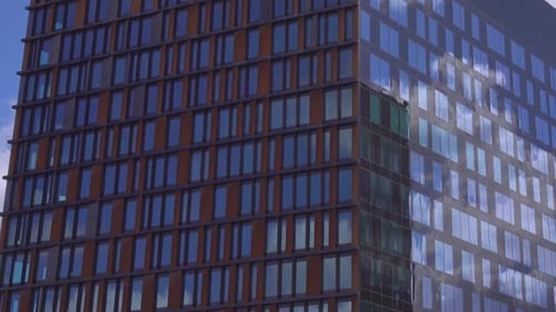 Modern Building with Reflective Windows Under Cloudy Sky