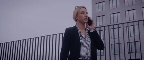 Woman Talking on Smartphone Near City Building