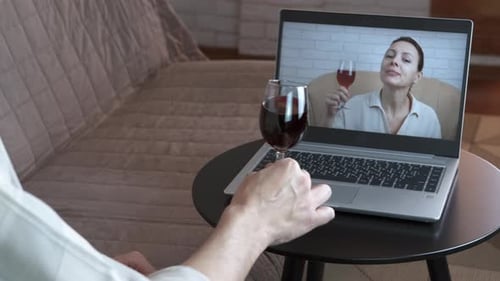 Adults Video Conferencing with Red Wine Glasses
