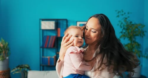 Mother Holding her Adorable Baby in Living Room