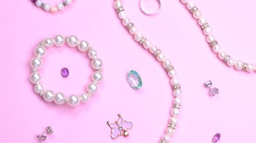 Pearls and Gemstones Arranged on Pink Surface