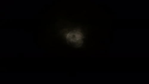 Mysterious Moon Obscured by Dark Clouds at Night
