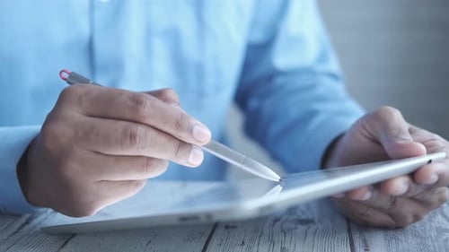Hands Using Tablet with Stylus on Desk