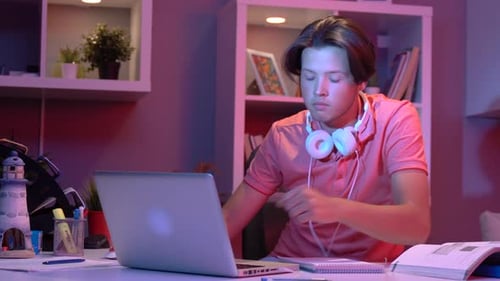 Focused Teenager Studying with Laptop and Notebook