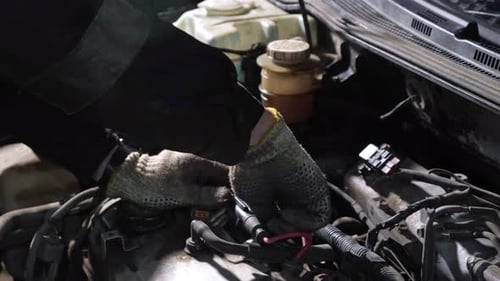 Car Mechanic Fixing Engine in Dark Garage