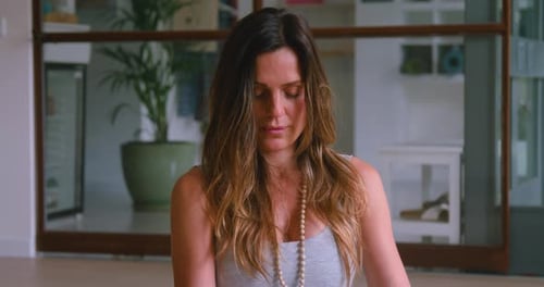 Woman Meditating Calmly with Eyes Closed Indoors