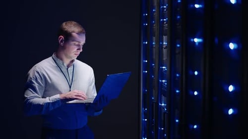 IT Technician in Data Center Digital Server Room Controlling Work of Rack Server Cabinets with a