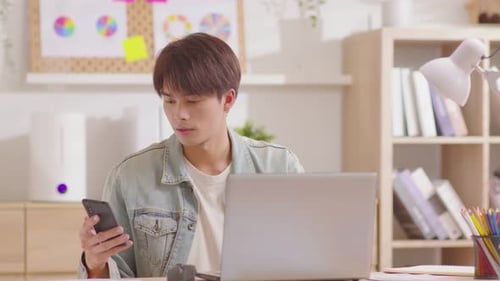 Young Adult Working at Desk and Talking on Phone