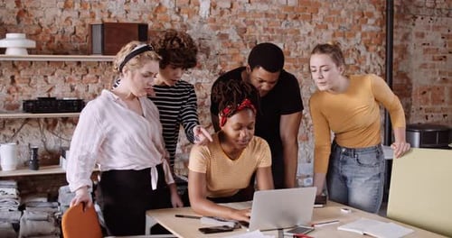 Group of Young Adults Working Together on Laptop