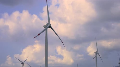 Rotating Windmills Producing Renewable Energy on Cloudy Day