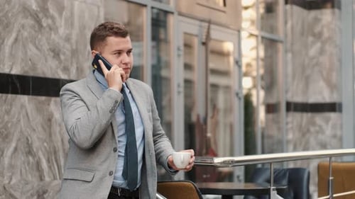 Young Professional Man Talking on Phone With Coffee