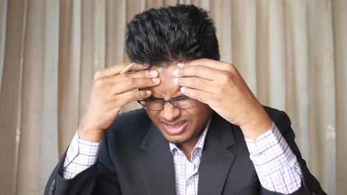 Stressed Young Adult Suffering from a Headache