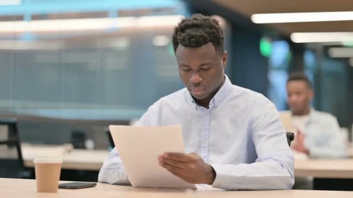 African Businessman Reading Documents in Office