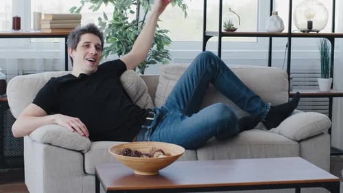 Caucasian Young Adult Man Millennial Guy Wears Black Tshirt and Jeans Falls Down Lie on Soft