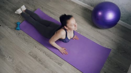 Woman Doing Cobra Pose on Yoga Mat Indoors