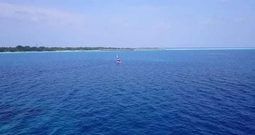 Daytime fly over clean view of a sunshine white sandy paradise beach and blue water background in hi
