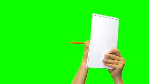 Hands Writing Down Something in Notebook