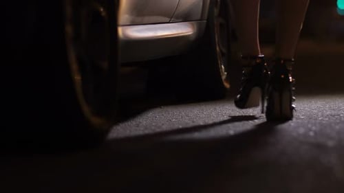 Woman Exits Car at Night Wearing High Heels