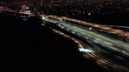 Aerial flyover traffic jam interchange road at night, drone shot top down view roadway intersection