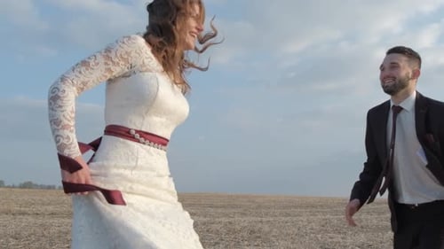 Happy Young Couple Holding Hands Run Through a Wide Field Having Fun Outdoors Countryside Man
