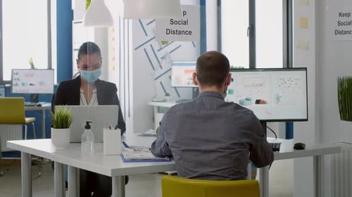 Travailleurs d'équipe portant des masques faciaux pendant leur travail chez Marketing Project