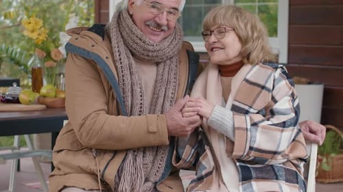 Elderly Couple Holding Hands Outside Their Rural Home