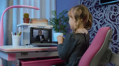 Child Attends Class Remotely at Desk