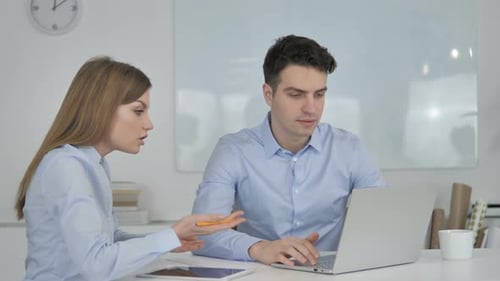 Man and Woman Discussing Project at Work