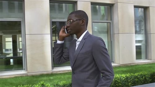 African American Businessman Talking on Cell Phone, Standing in Front of His Office. Slow Motion