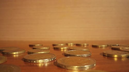 Golden Coins Scattered on Reflective Surface