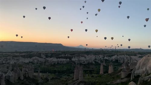 Hot-air balloons flying over the mountain landsape of Cappadocia, Turkey.