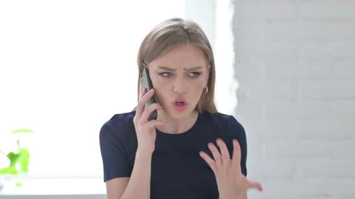 Frustrated Woman Arguing on Mobile Phone Indoors