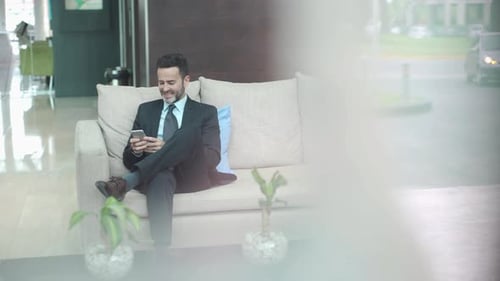 Man in building lobby using smart phone