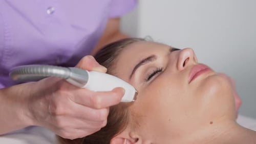 Woman Receiving Rejuvenating Facial Treatment in Clinic