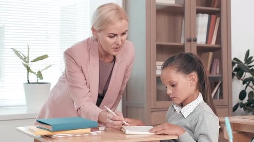 Teacher Helping Student with Assignment in Classroom