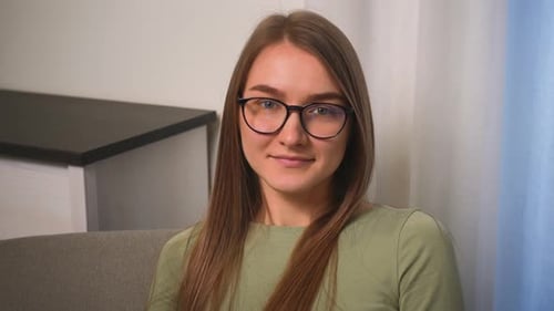 Confident Smiling Young Woman in Glasses Looking at Camera Standing at Home Office