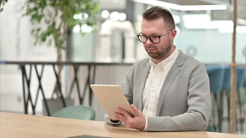 Man Uses Tablet in Modern Office Setting